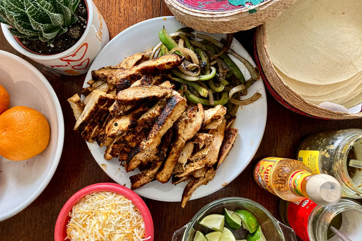 Grilled chicken with warm tortillas, cheese and lime laid out for building
