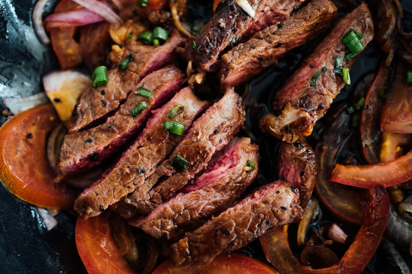 Strips of grilled steak cooked with red and green peppers and onions