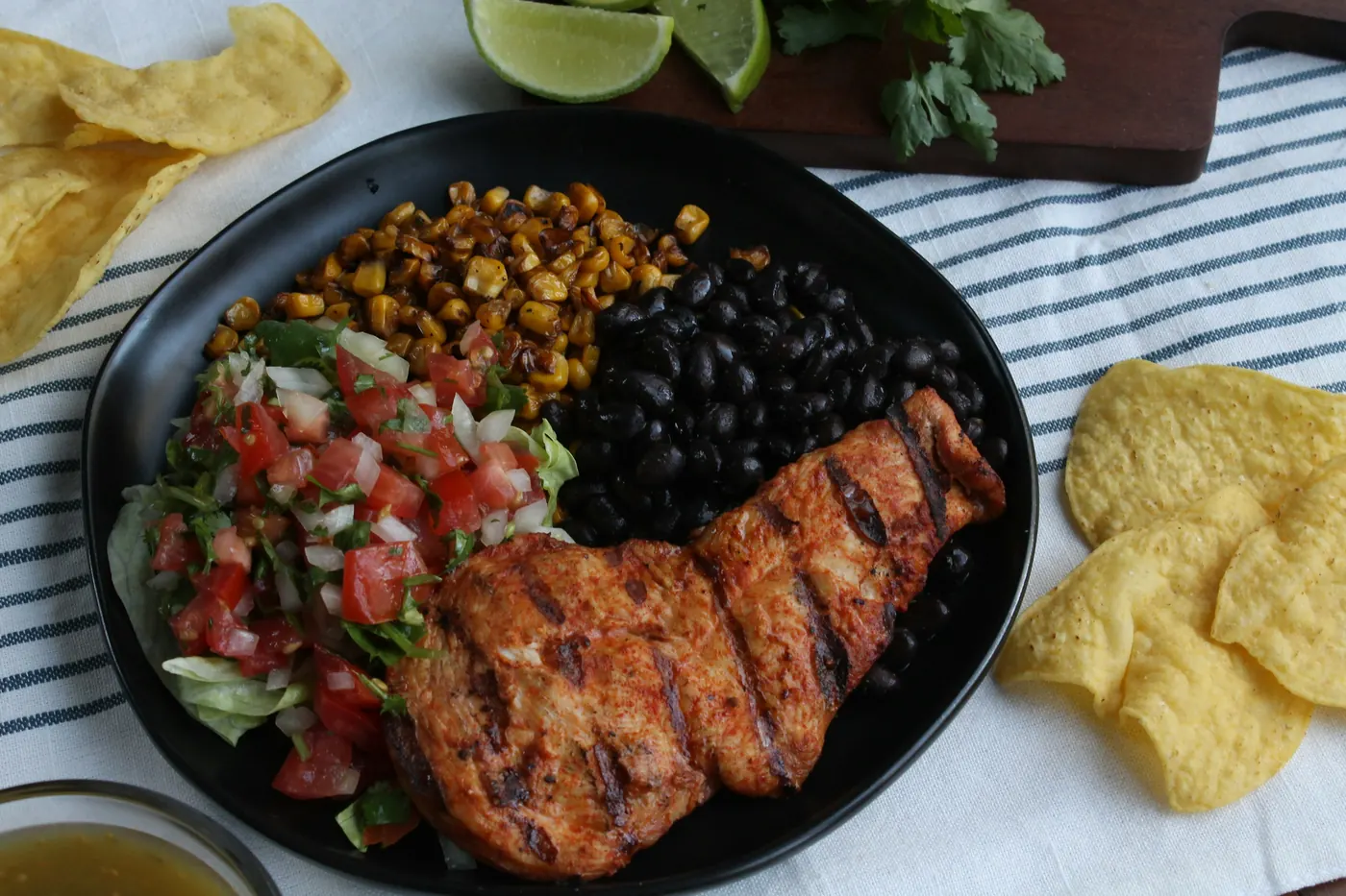 Grilled meat served with black beans, roasted corn and pico de gallo