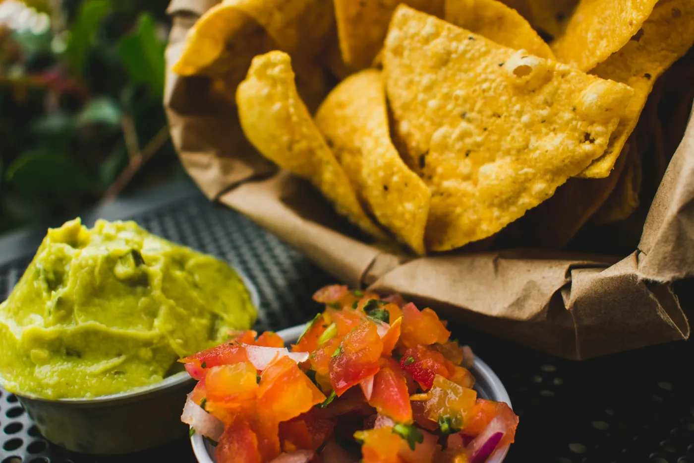 Bowls of guacamole and pico de gallo served with a basket of tortilla chips