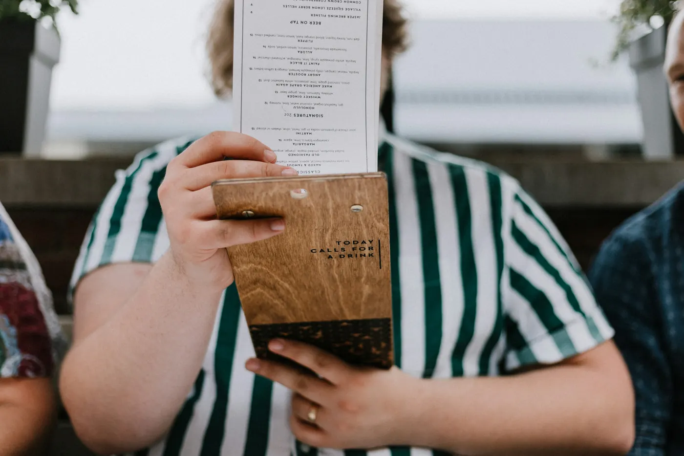 A person holding an open menu up while deciding