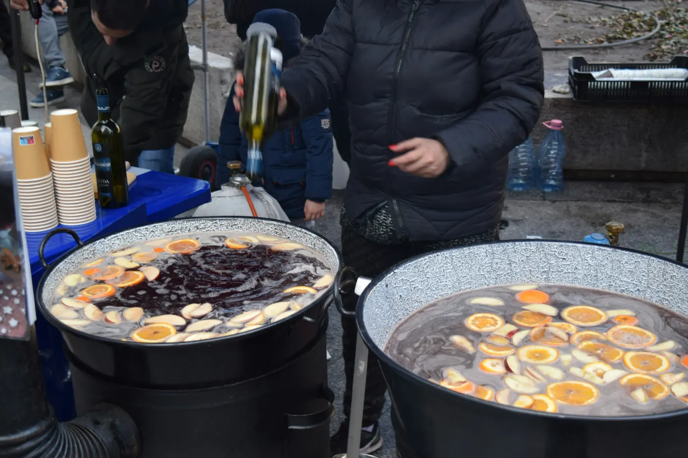 Two large steaming pots of fruit punch at an outdoor stall