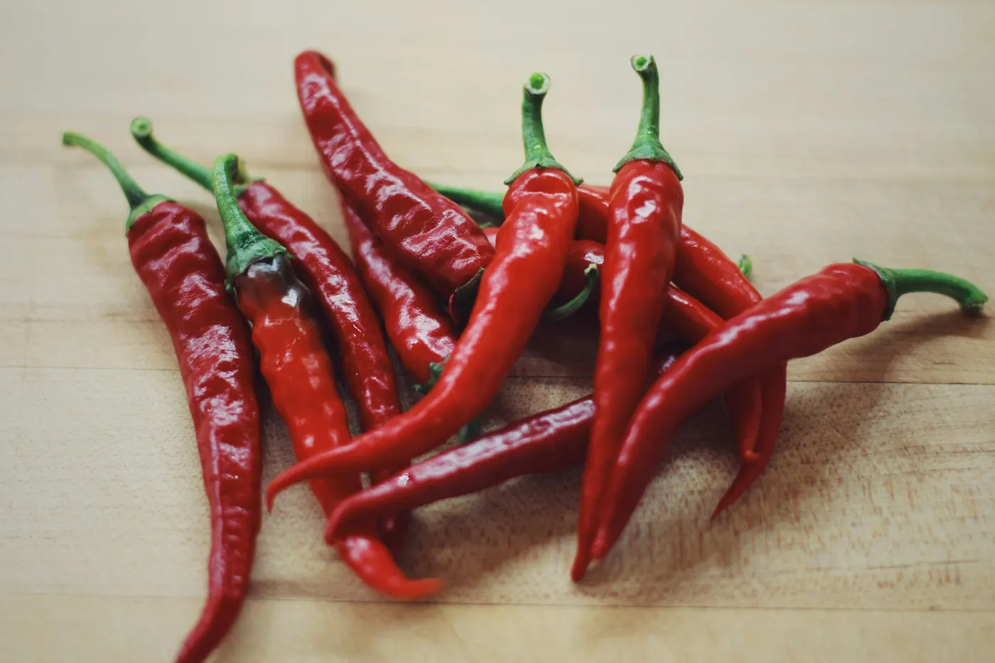 Long dried red chiles resting on a wooden board