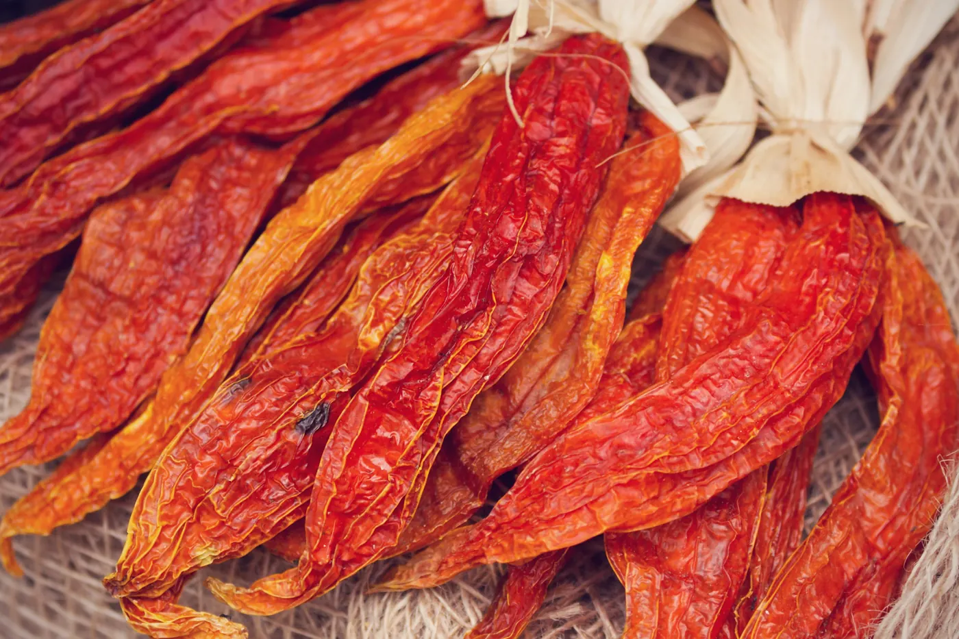 Long red dried chiles spread out at a market stall
