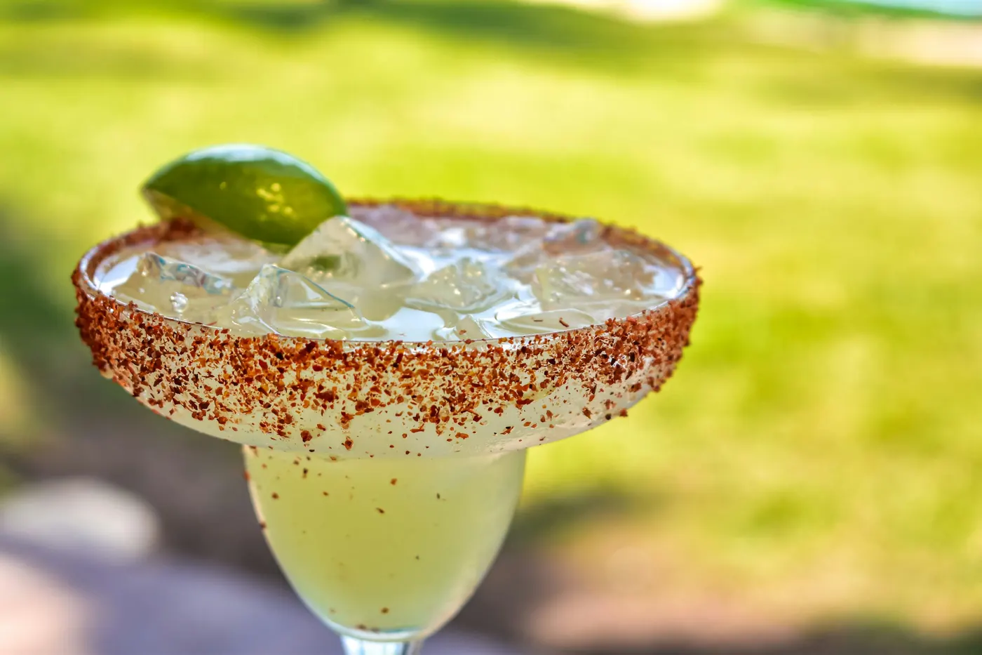 A margarita on the rocks with a chile-salt rim and lime wheel