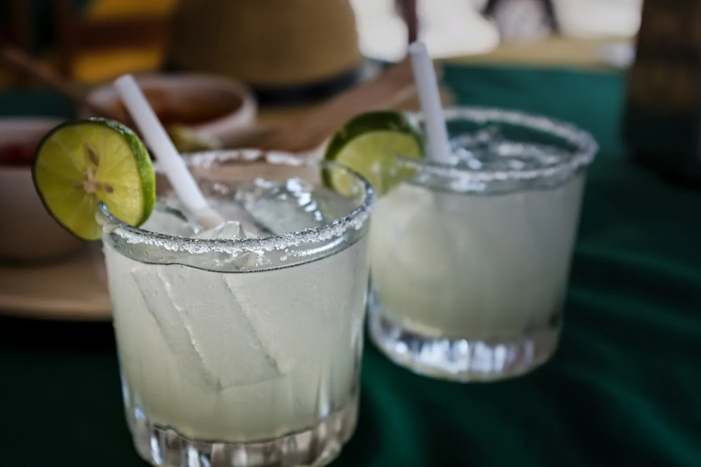 Two margaritas on the rocks in short tumblers with lime and salt