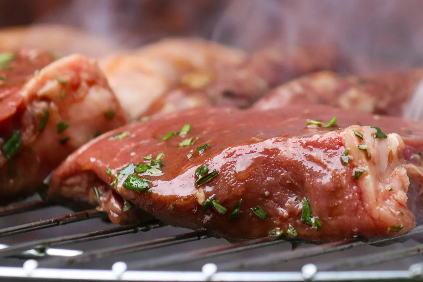 Marinated meat cooking over a grill