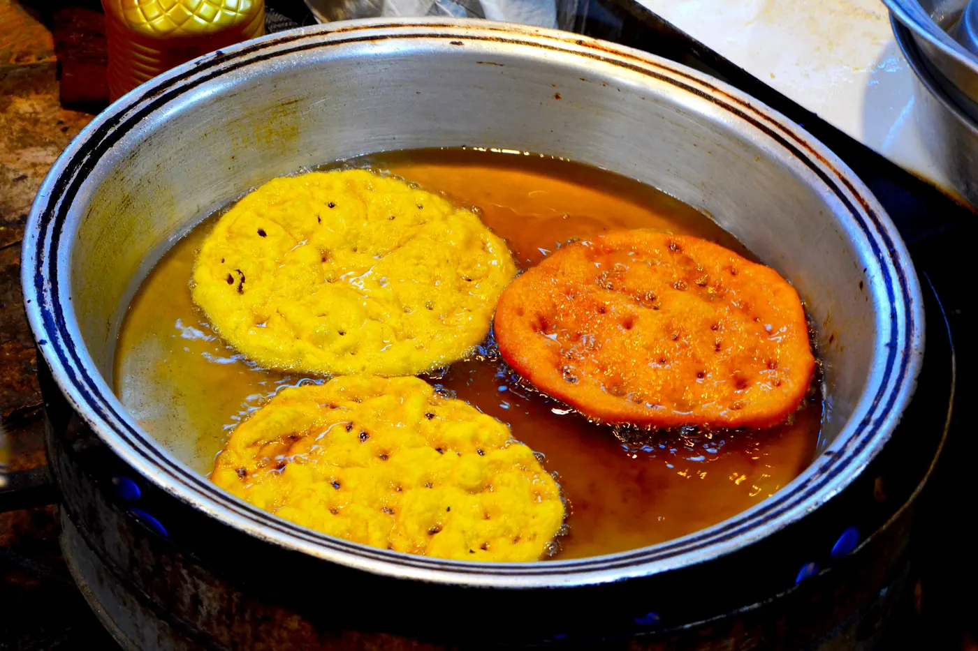Masa discs frying in shallow oil in a wide pan