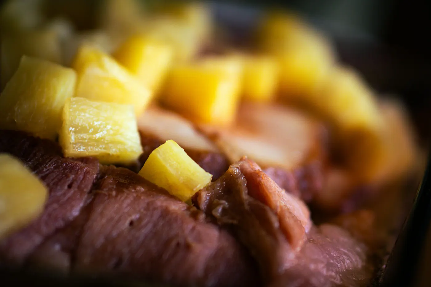 Cooked meat topped with small chunks of pineapple