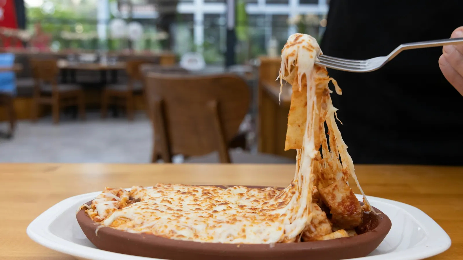 Melted cheese stretching in long strands as a quesadilla is lifted
