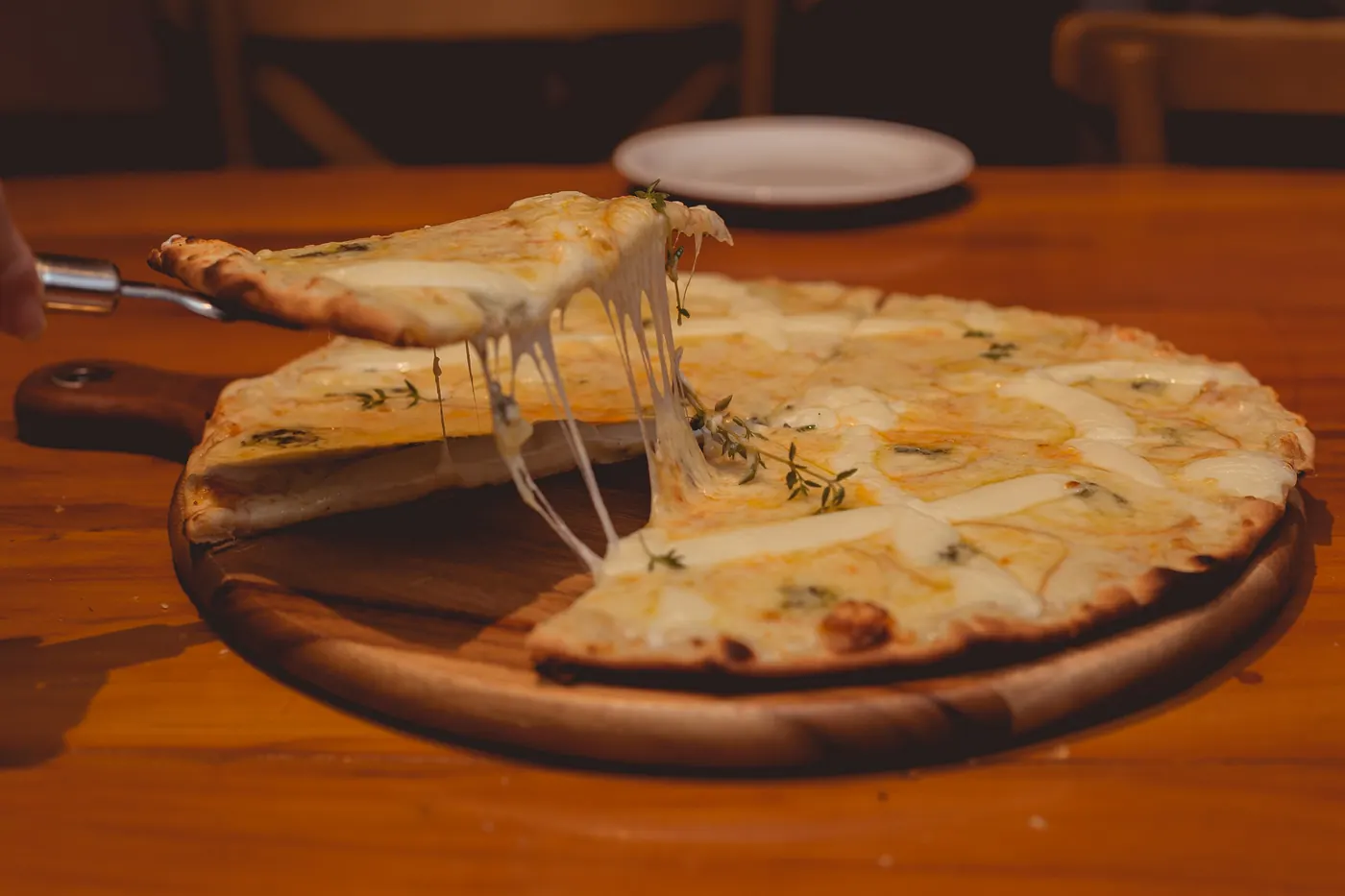 Melted cheese stretching from a cut round flatbread