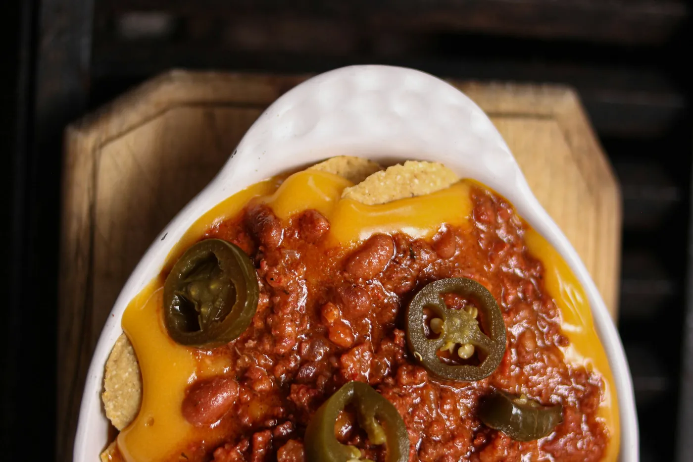 Tortilla chips topped with melted cheese, chili and sliced jalapeños