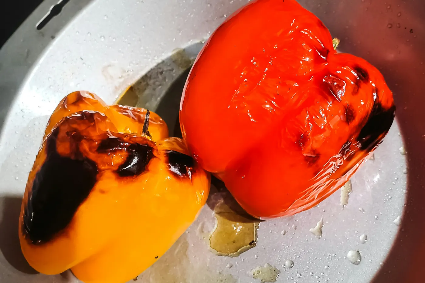 A charred pepper being peeled, blistered skin coming away