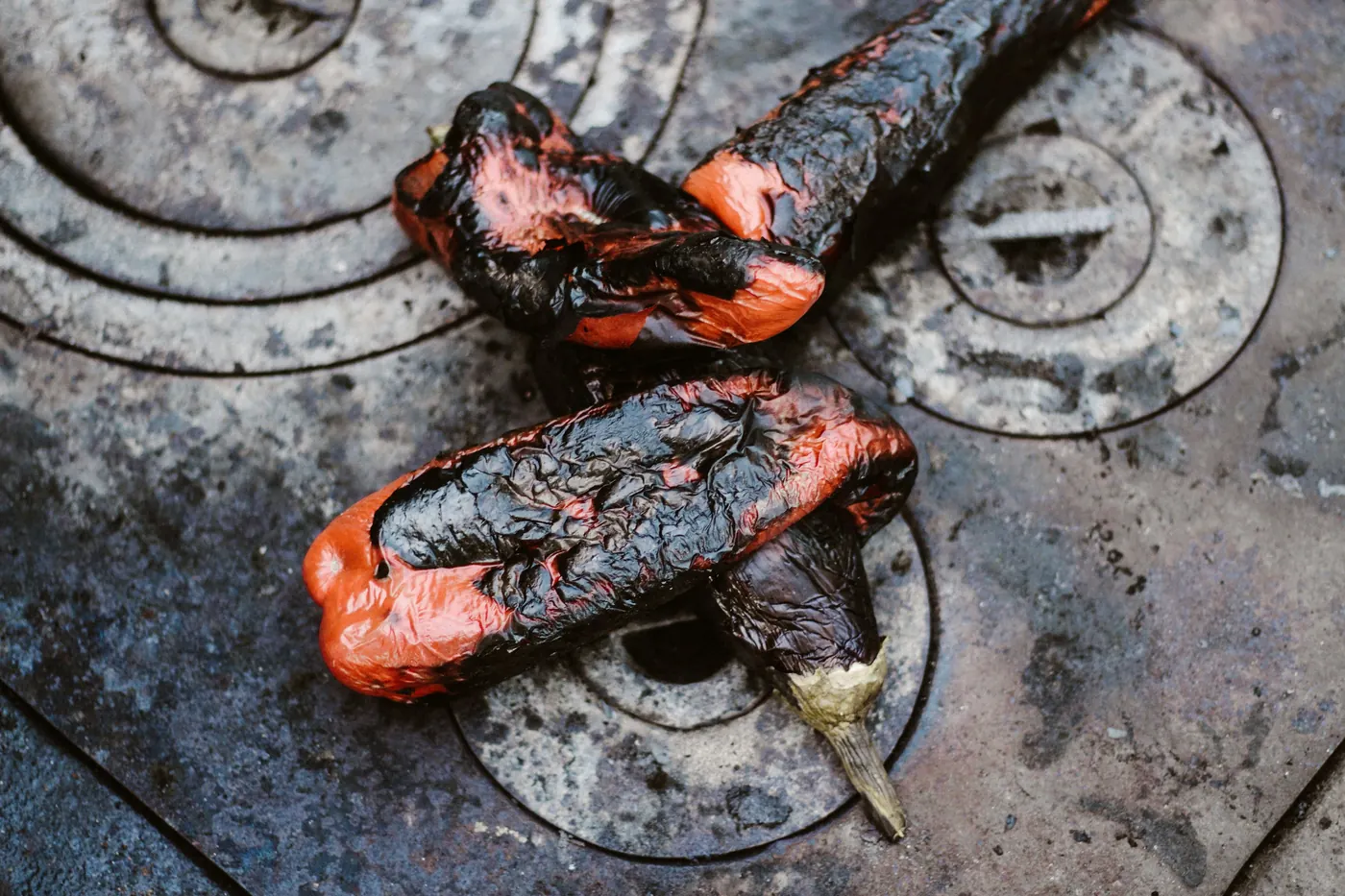 Peppers charring black on a hot metal surface
