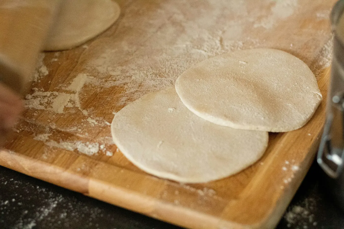 Pressed rounds of tortilla dough on a wooden board