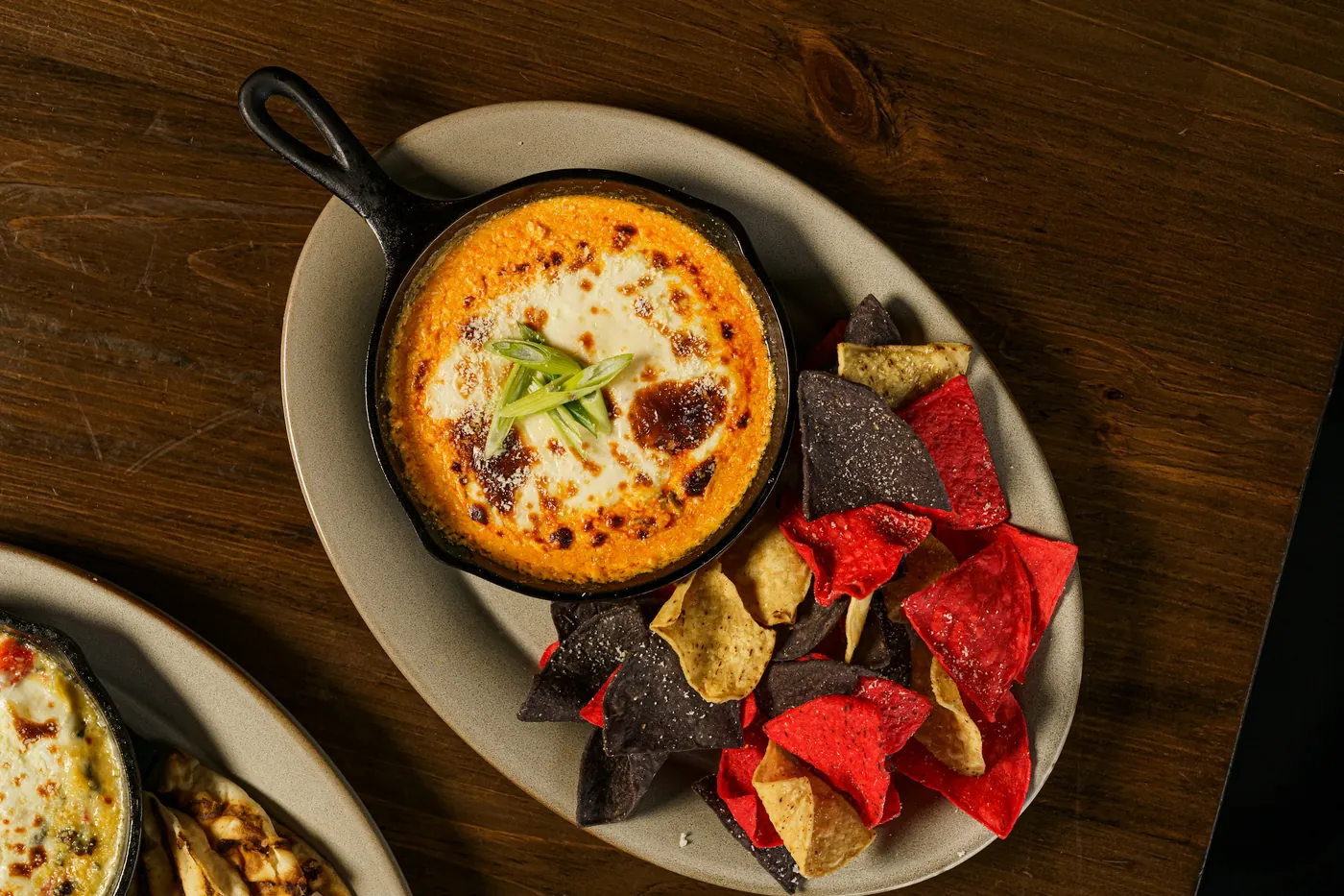 Melted cheese served bubbling in a small cast iron dish with tortilla chips
