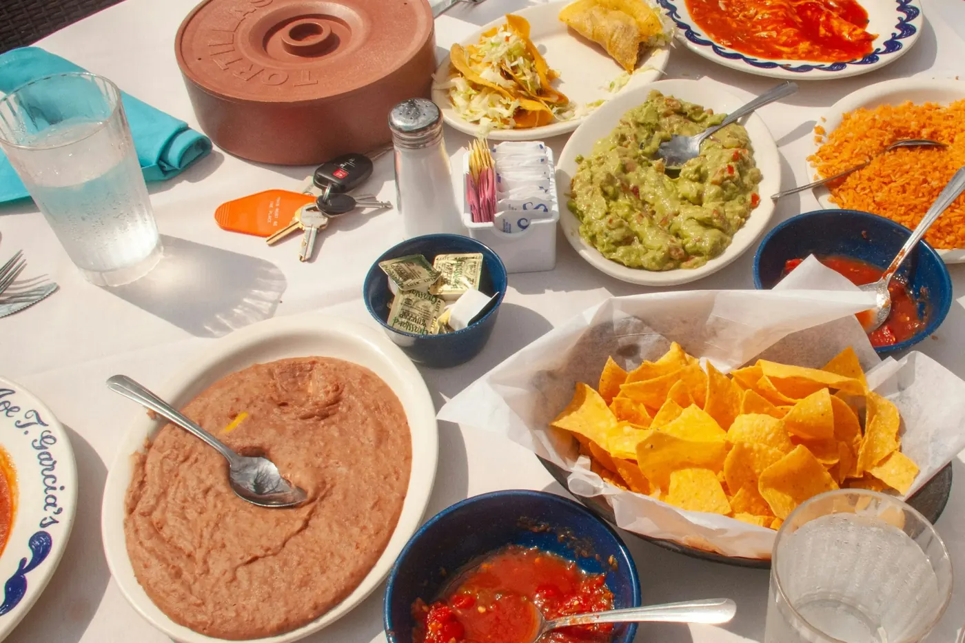 Refried beans, tortilla chips and bowls of salsa spread across a table