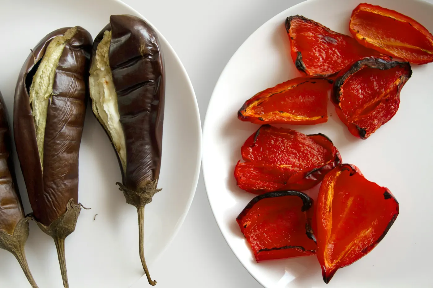 Roasted and peeled peppers arranged on a white plate