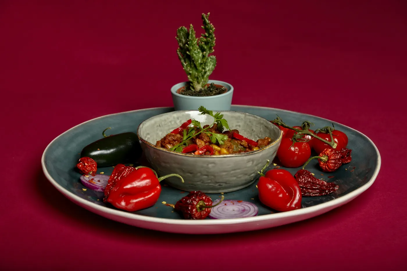 Roasted red peppers and chiles arranged on a dark plate