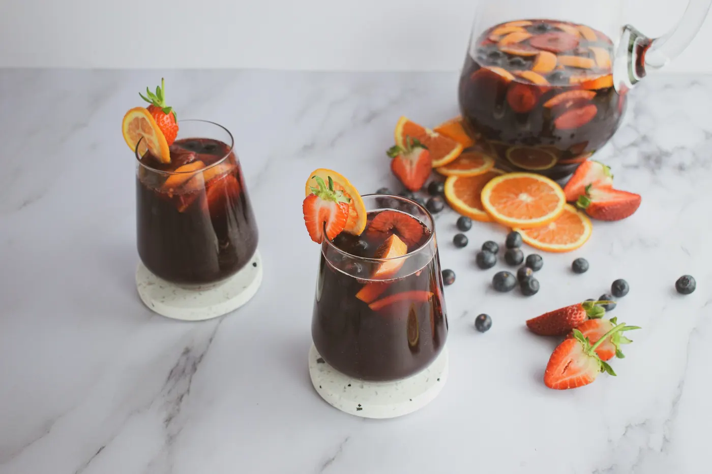 Glasses of red sangria with fresh strawberries and orange slices