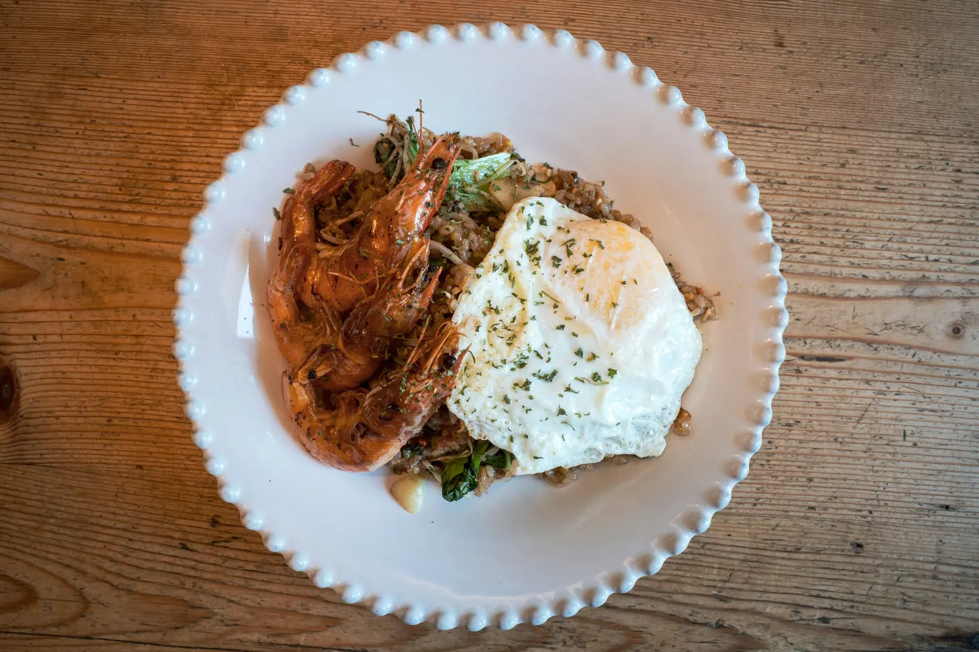 Saucy shredded meat topped with a fried egg in a shallow bowl