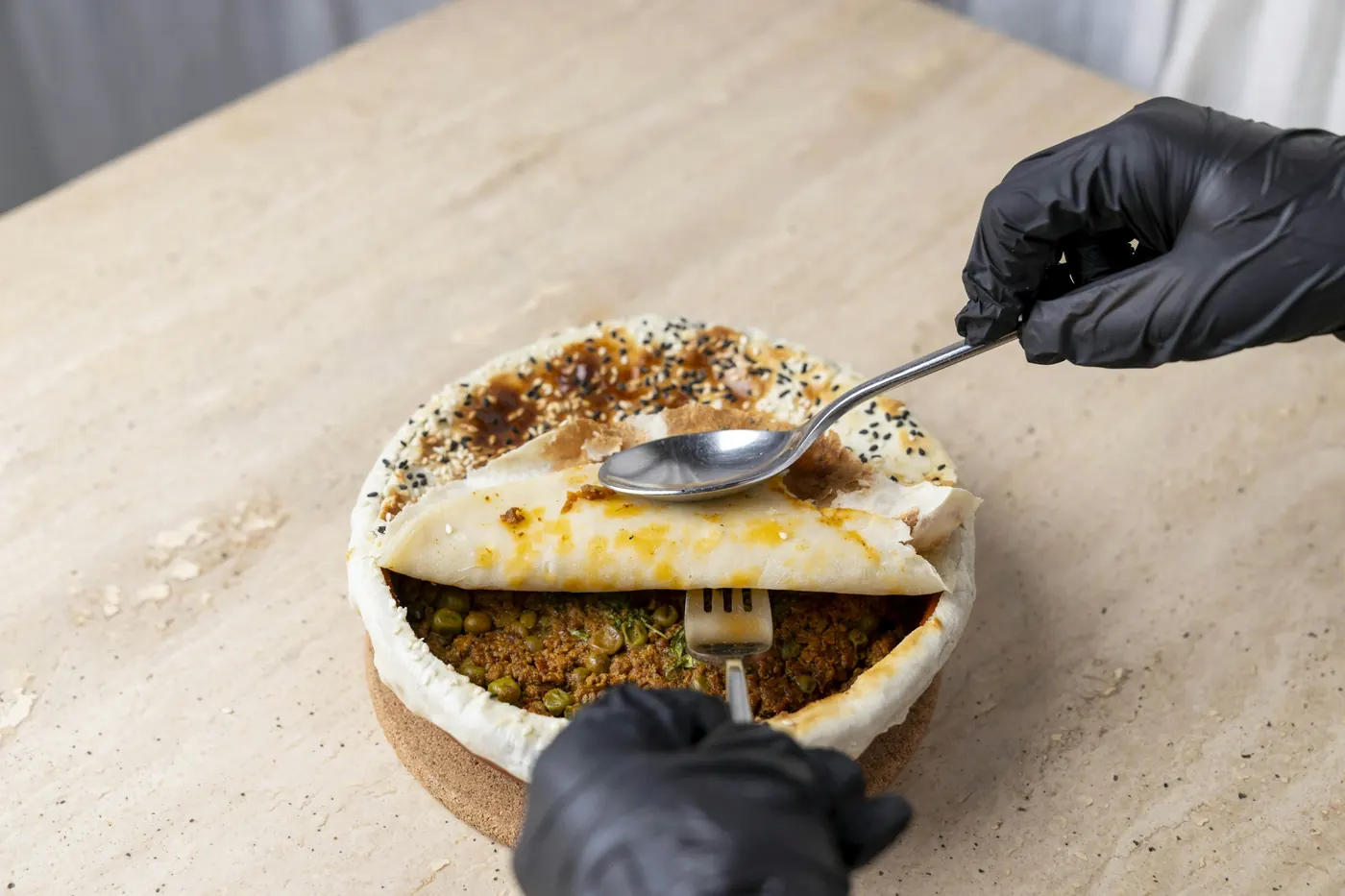 A spoon scattering toasted seeds over a plated dish