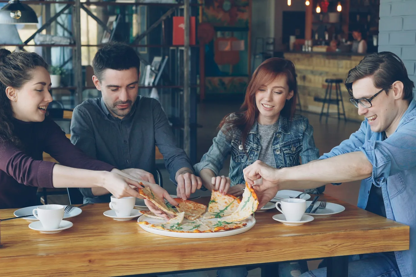 A group of people sharing plates of food around a restaurant table