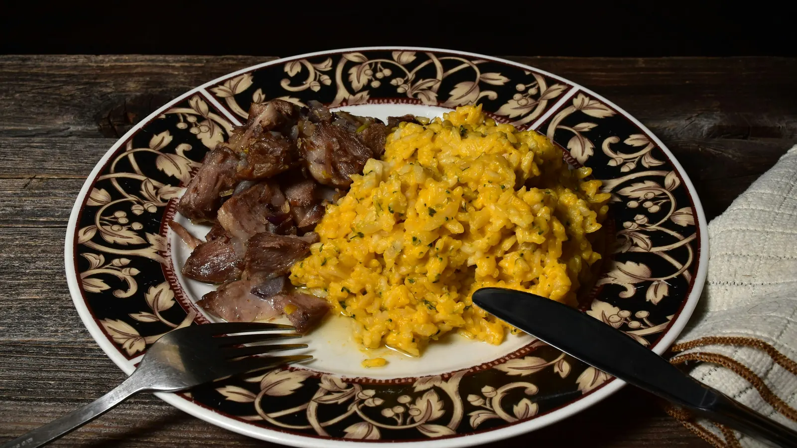 Shredded dark beef scrambled with egg on a decorated ceramic plate