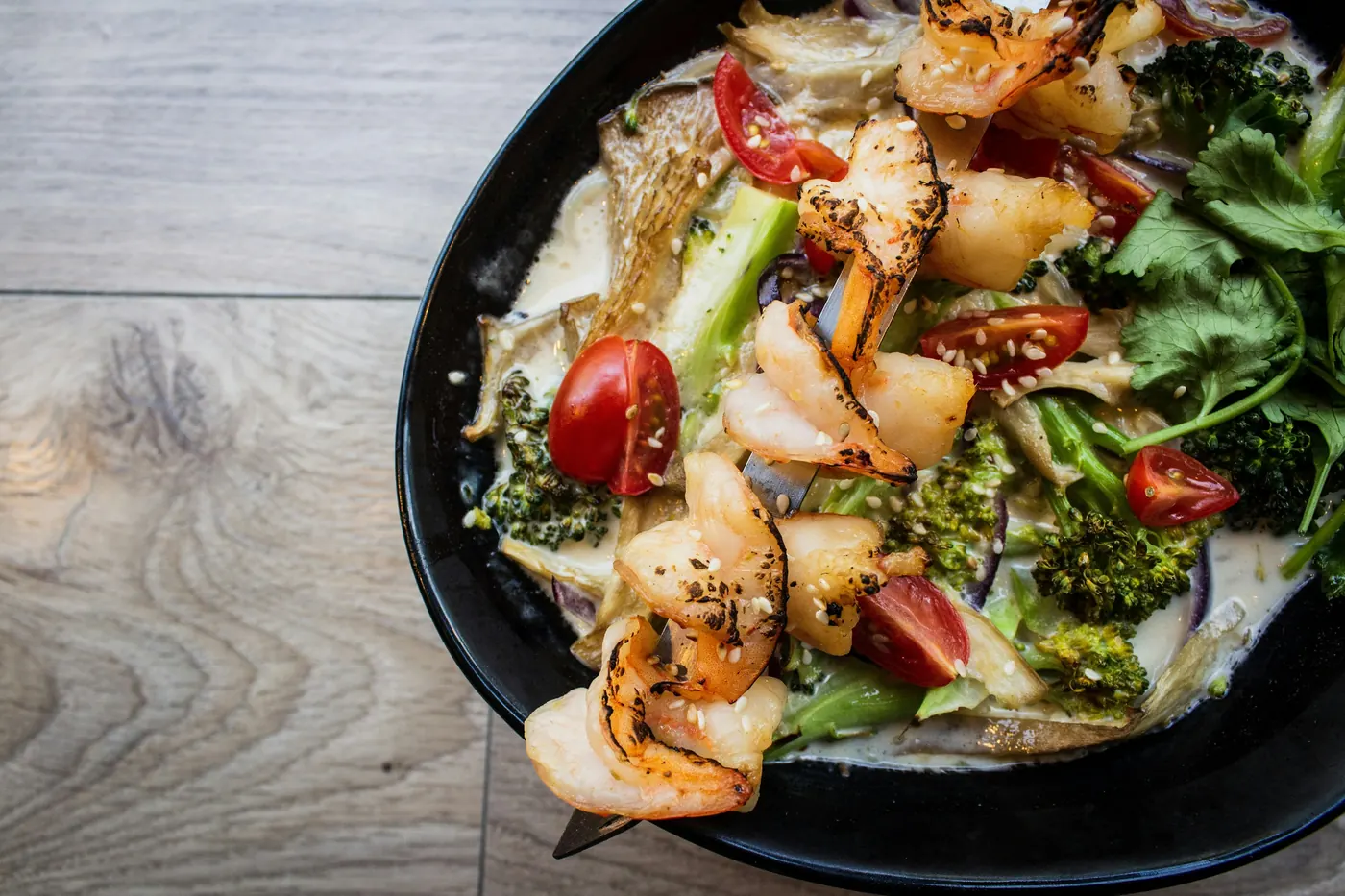 Shrimp and mixed vegetables in a dark skillet