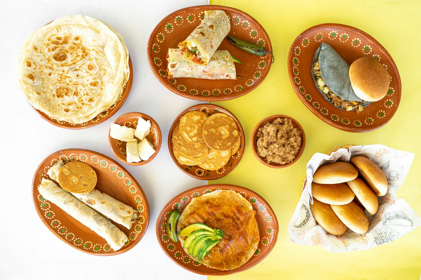 Small clay dishes holding a variety of different foods