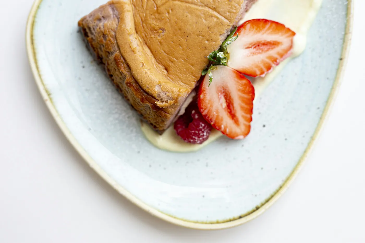 A slice of pale sponge cake topped with fresh sliced strawberries