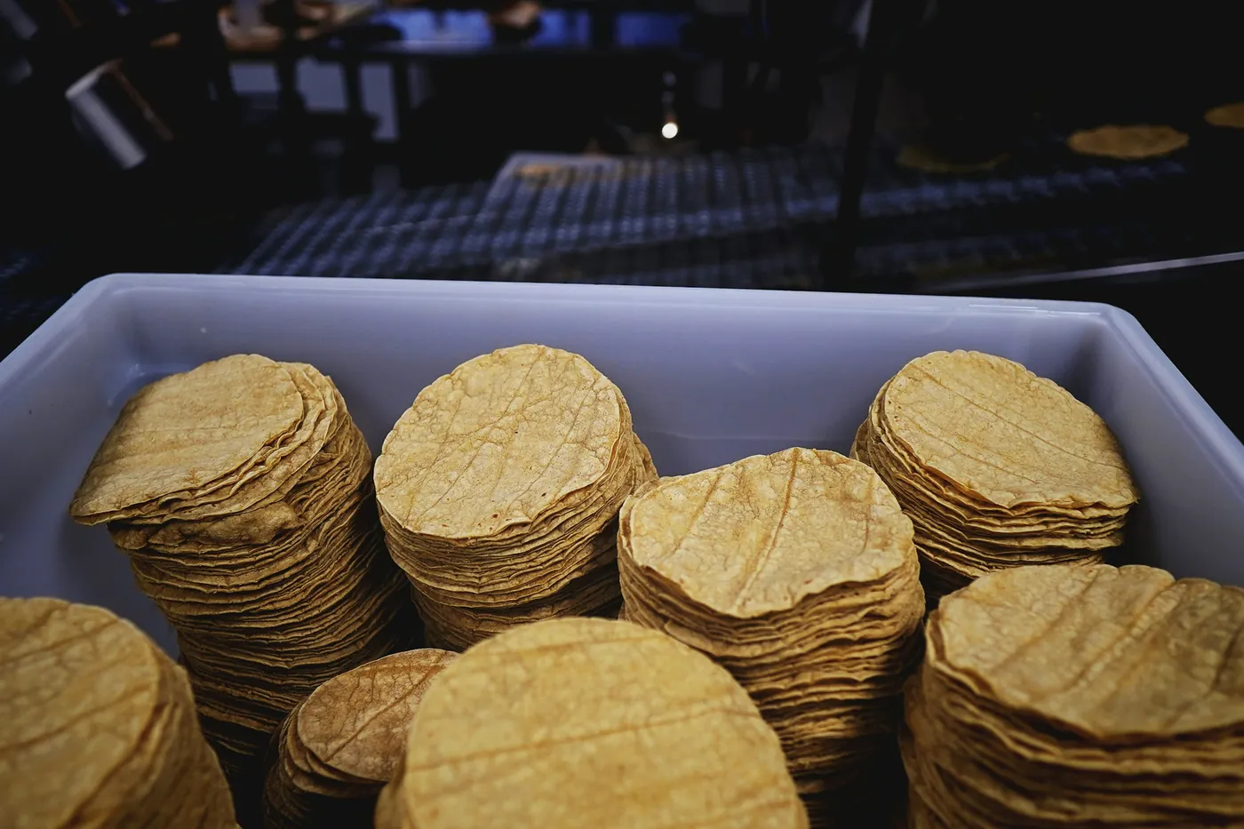 Stacks of yellow corn tortillas in a metal tray