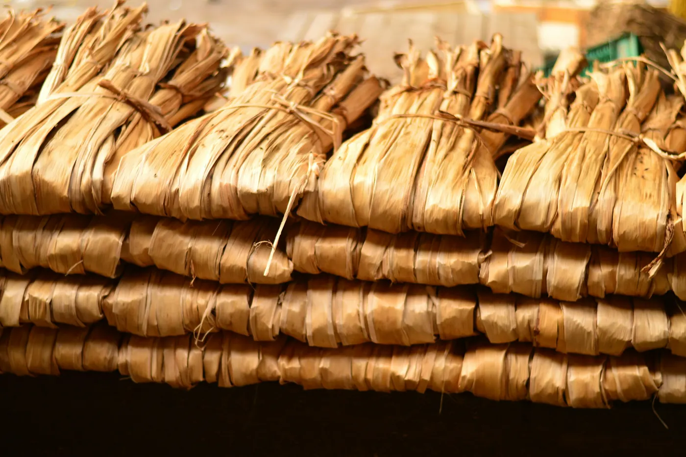 Stacks of tamales tied closed with strips of corn husk
