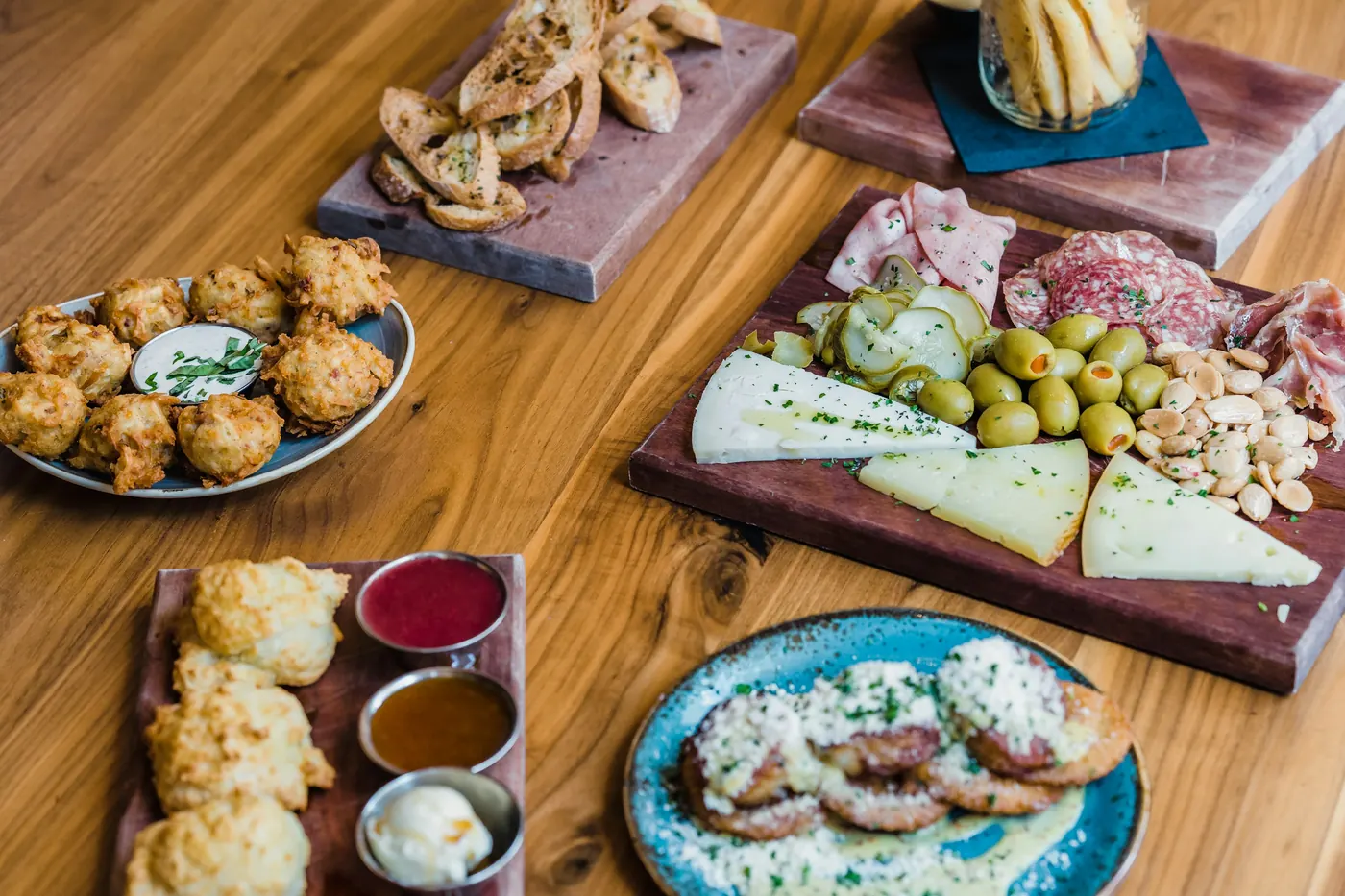 Wooden boards of cured meats, cheeses and olives on a table