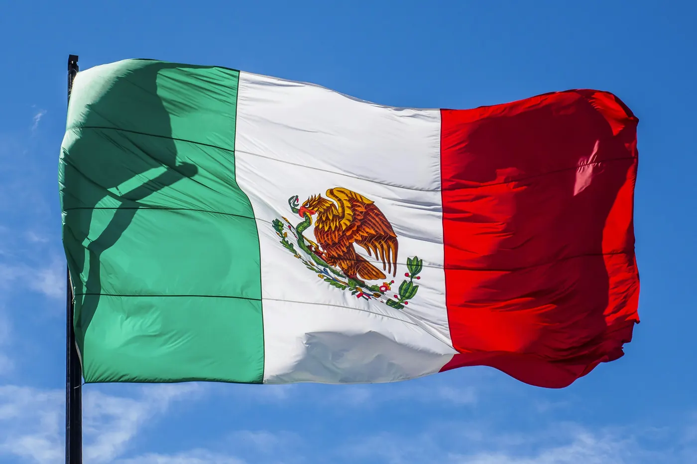 The Mexican flag flying against a clear blue sky