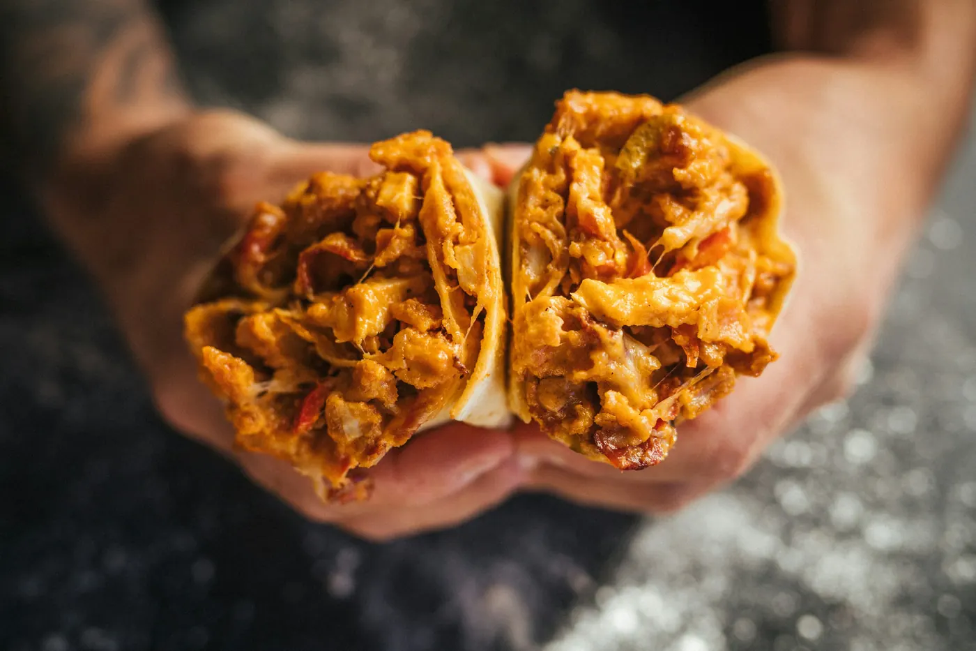 Two small tacos held up in a pair of hands