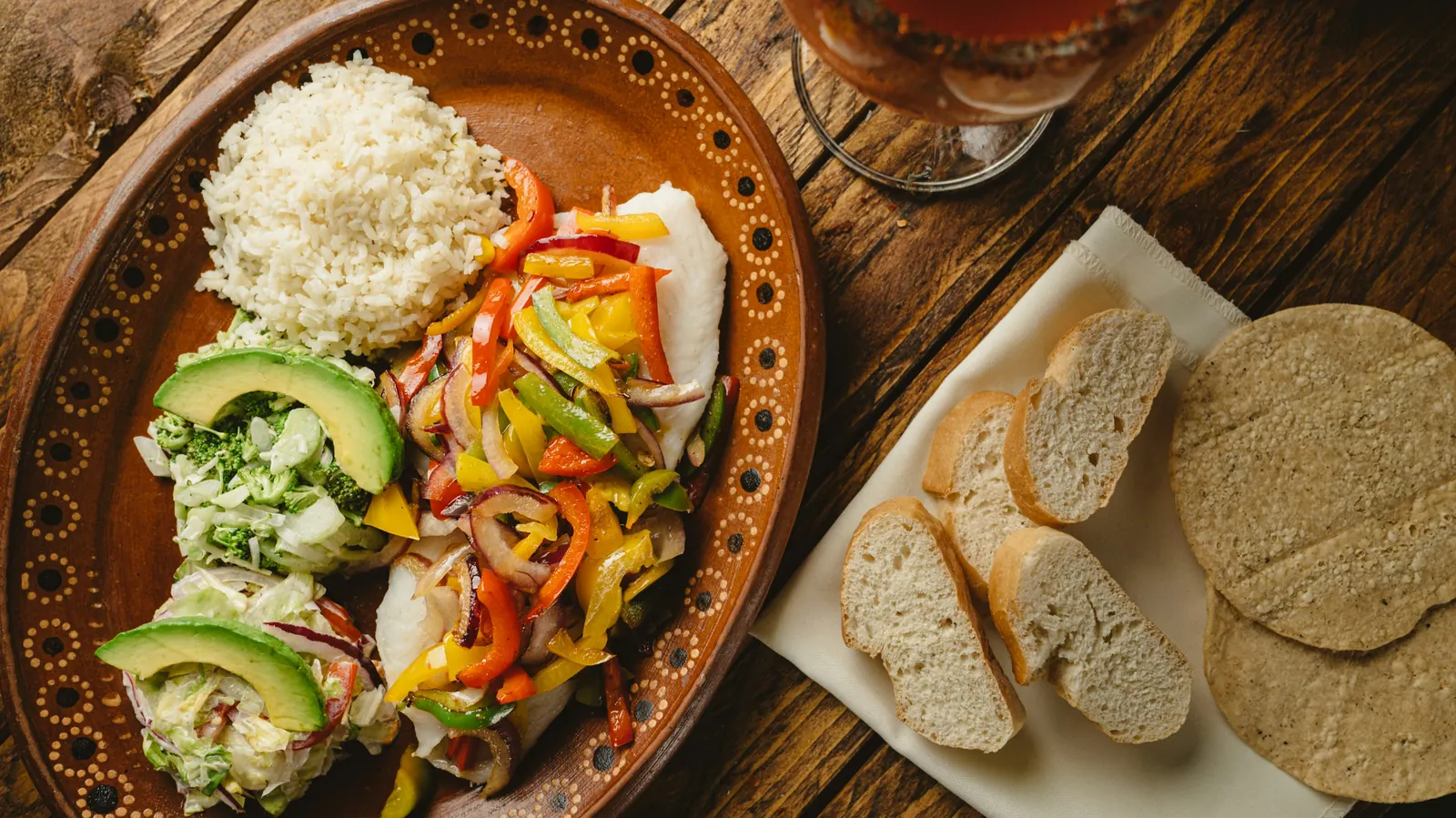 A plate of peppers, avocado and rice served with warm tortillas