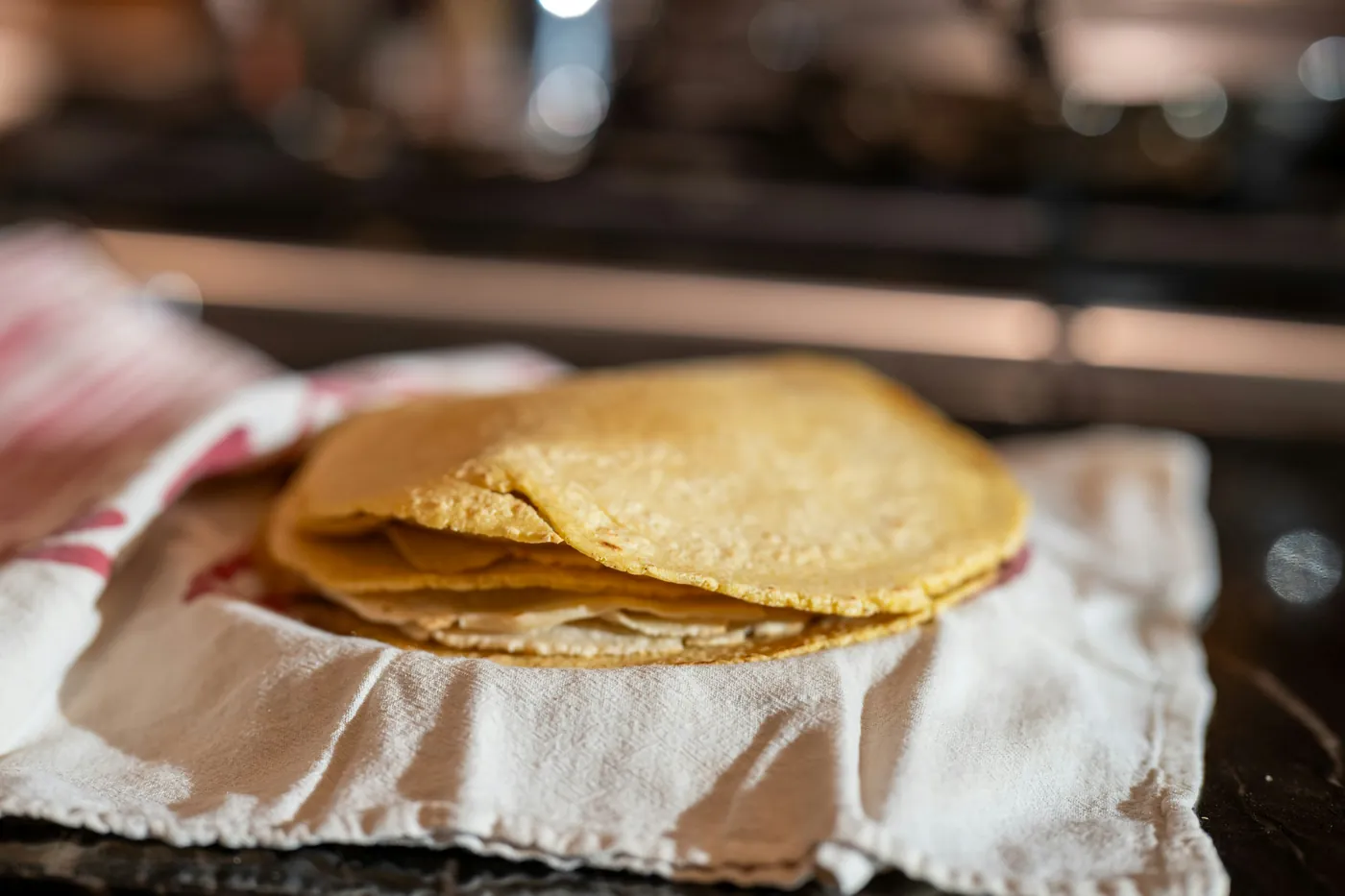 Warm corn tortillas wrapped in a cloth napkin