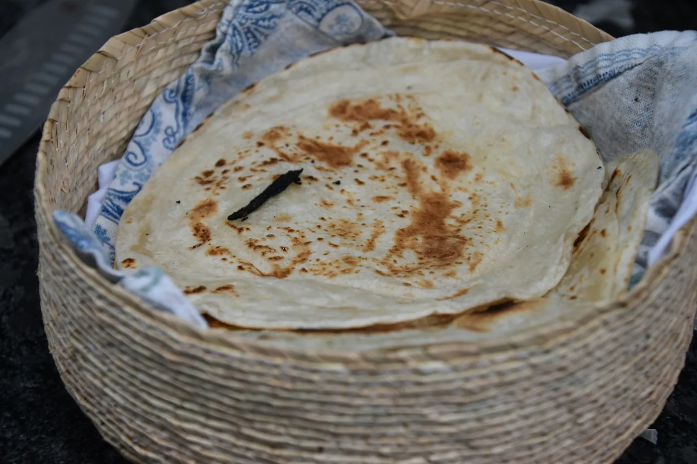 A basket of warm flour tortillas wrapped in cloth